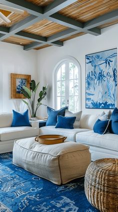 a living room filled with white furniture and blue accents