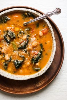 a bowl of soup with spinach and chickpeas in it on a plate