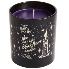 a black candle with white writing on it and stars in the sky behind it, which reads