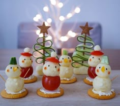 small christmas trees and snowmen made out of cookies on a table with lights in the background