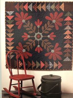 a red rocking chair sitting next to a quilt