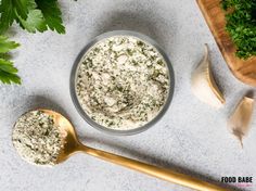 a bowl of food next to two spoons and some parsley