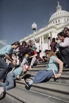 people sitting on the steps in front of the capitol building