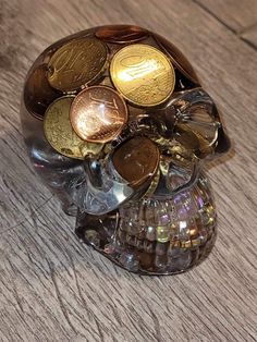 a skull made out of coins sitting on top of a wooden table