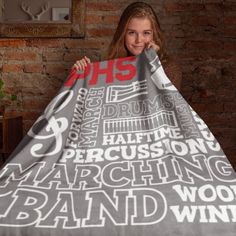 a woman holding up a blanket with words all over it