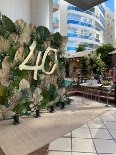 a large number sign sitting on the side of a building next to tables and chairs