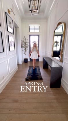 a woman walking down a hallway in front of a door with the words spring entry on it