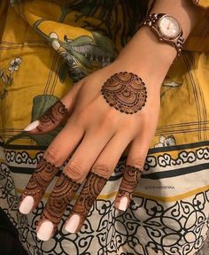 a woman's hand with henna tattoos on it