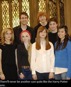 a group of people standing next to each other in front of a stained glass window