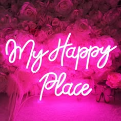 a neon sign that says, my happy place on it in front of pink flowers