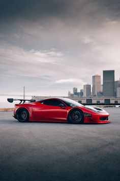 a red sports car parked in front of a city skyline