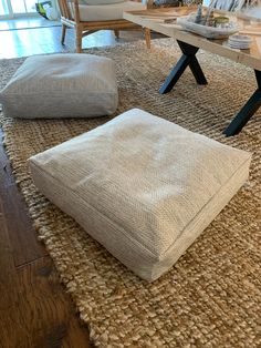 a living room filled with lots of furniture and pillows on top of a carpeted floor