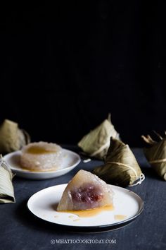 two white plates with food on them next to some leaves