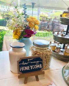 a table topped with jars filled with honeycombs next to a sign that says honeycomb