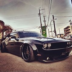 a black sports car is parked on the street