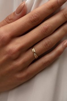 a woman's hand wearing a gold wedding band