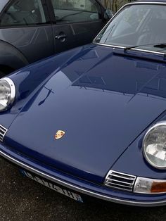 a blue sports car parked next to other cars