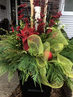 a christmas planter with evergreen, poinsettis and pine cones