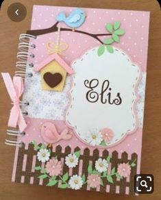 a pink and brown card with birds, flowers and a birdhouse on it's side