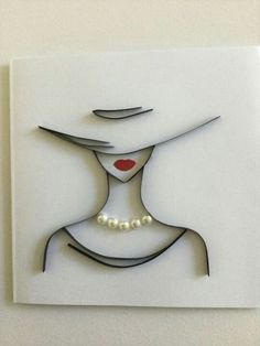 a woman's face with a hat and pearls on the necklace is cut out of paper