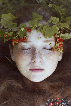 a woman with freckles and berries on her head