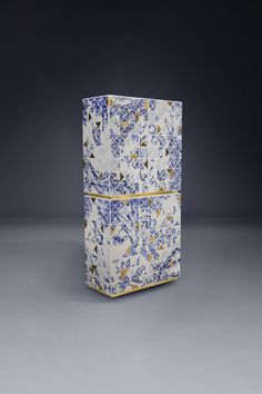 a blue and white box sitting on top of a gray floor next to a wall