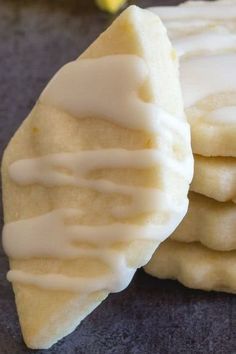 a stack of cookies with icing on top of each other next to a banana