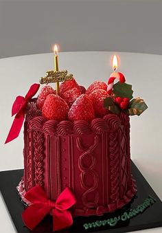 a red cake with candles and decorations on it