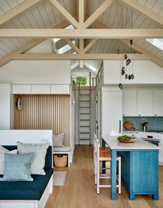 a kitchen and living room are separated by an open floor plan, while the stairs lead up to the second floor