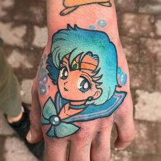 a hand with a little mermaid tattoo on it