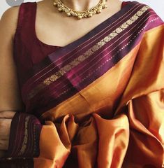 a woman wearing an orange and purple saree