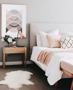 a bed room with a neatly made bed and a white rug on the floor next to it