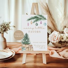 a wooden easel with a christmas card on it next to some flowers and plates