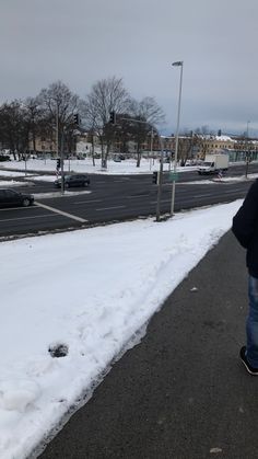 a man is walking down the street in the snow