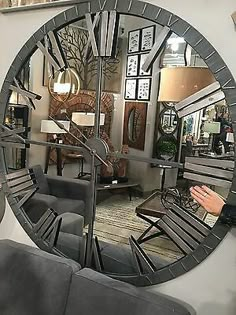 a large round mirror sitting on top of a wall next to a couch and table