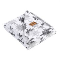 the white and black blanket is folded on top of each other, with an orange tag