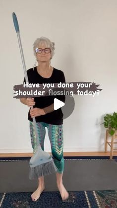 an older woman holding a broom and wearing leggings