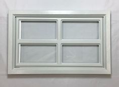 a white window with four panes on the outside and one in the inside, against a white wall