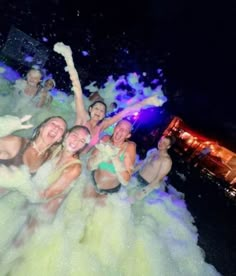 some people are having fun in the water and spraying them with colored powder on their faces