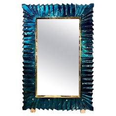 a mirror that is sitting on top of a wooden stand with blue paint and gold trimming