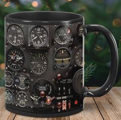 a black coffee mug with various gauges and dials in front of a christmas tree