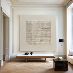 a living room with white walls and wood flooring on the floor, along with a coffee table in front of it