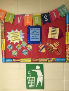 a bulletin board on the wall in a classroom with hand prints and other items hanging from it