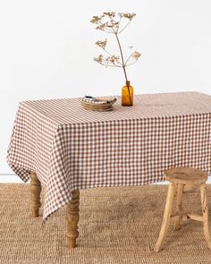 a table with a checkered cloth on it and a small wooden stool next to it