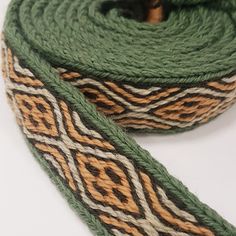 a green and brown rope with an intricate design on it