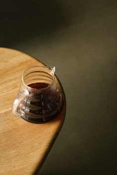 a small glass pitcher sitting on top of a wooden table