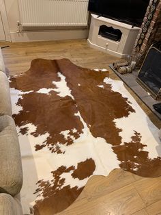 a brown and white cowhide rug in a living room