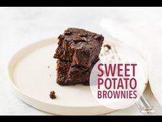 a white plate topped with brownies on top of a table next to a fork