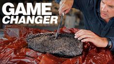 a man is cutting into a large piece of meat with a knife and some plastic wrap around it