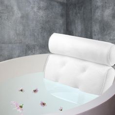 a white bath tub sitting next to a gray wall with flowers on it and a towel hanging from the edge